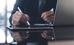 A business person performs a digital signature with a tablet and stylus