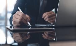 A business person performs a digital signature with a tablet and stylus