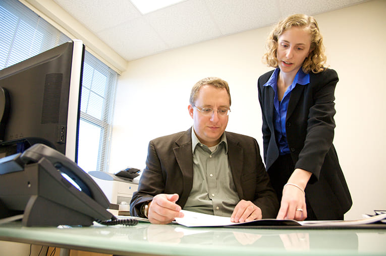 Two business people review some marketing reports