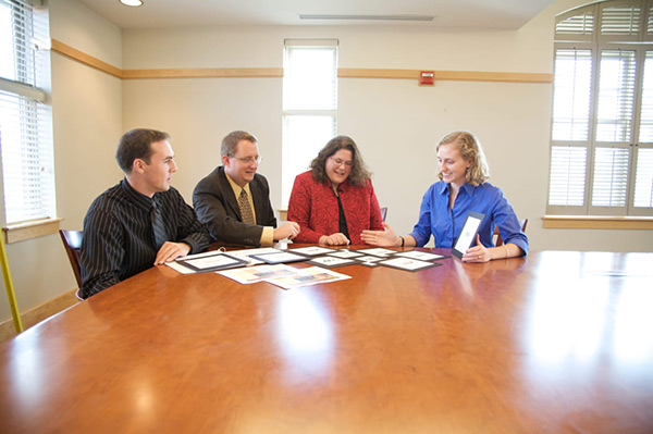 Four business people have a meeting at a large table