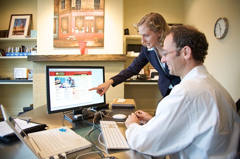 Two co-workers reviewing a monitor and working on a brand platform