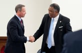 Two business people in suits have a firm handshake