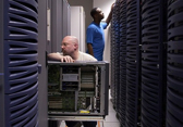 An IT professional inspects a piece of hardware