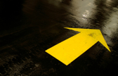 A large, yellow arrow points in one direction on the ground