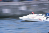 A small, white speedboat races across the water