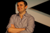 Gary Vaynerchuk stands with his arms crossed looking off to the side