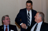 Three business people are having a discussion and two of them shake hands