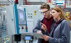 Two engineers review manufacturing equipment together