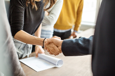 Two business people have a firm handshake to close a sales deal