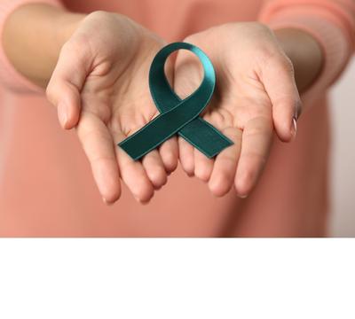 A person extends their hands showing a green ovarian cancer awareness ribbon